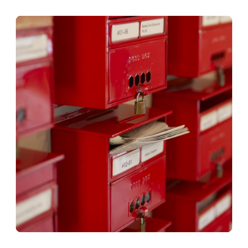 Boîtes aux lettres rouges remplies de courrier Rangée de boîtes aux lettres rouges métalliques, partiellement ouvertes, laissant apparaître du courrier à l’intérieur — une image évoquant les échanges, la correspondance et les petits messages du quotidien.