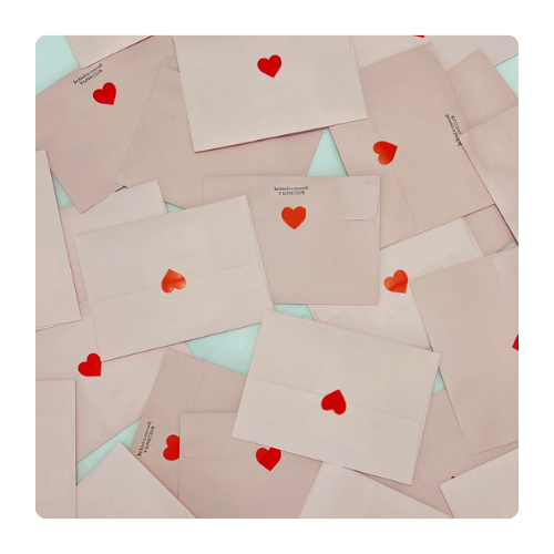 Enveloppes roses scellées d’un cœur rouge Plusieurs enveloppes rose poudré fermées par un autocollant rouge en forme de cœur, disposées à plat, évoquant la douceur, le partage et les petits mots attentionnés.